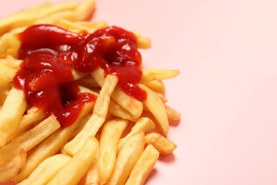 Photo of Tasty french fries with ketchup on pink background, closeup. Space for text