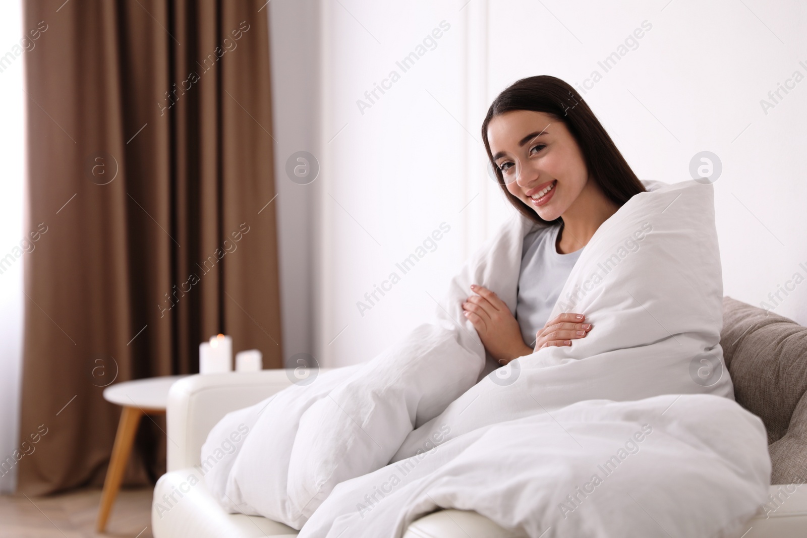 Photo of Woman covered in blanket resting on sofa, space for text