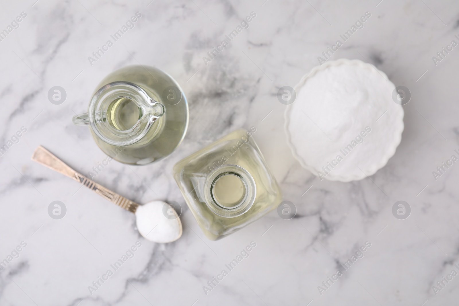 Photo of Vinegar and baking soda on white marble table, flat lay