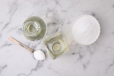 Vinegar and baking soda on white marble table, flat lay