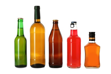 Bottles with different alcoholic drinks on white background