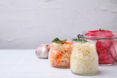 Photo of Delicious sauerkraut prepared according to different recipes on white table, space for text