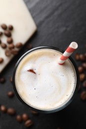 Photo of Refreshing iced coffee with milk in glass and beans on dark gray table, top view