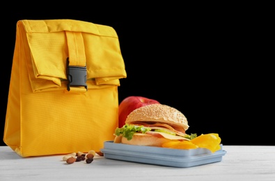 Photo of Lunch box with appetizing food and bag on table