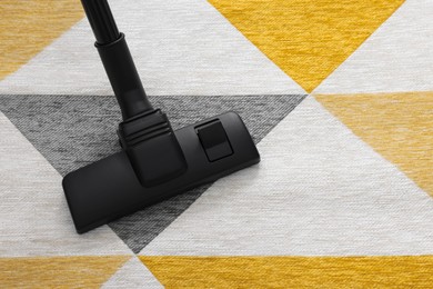 Photo of Hoovering carpet with vacuum cleaner, top view