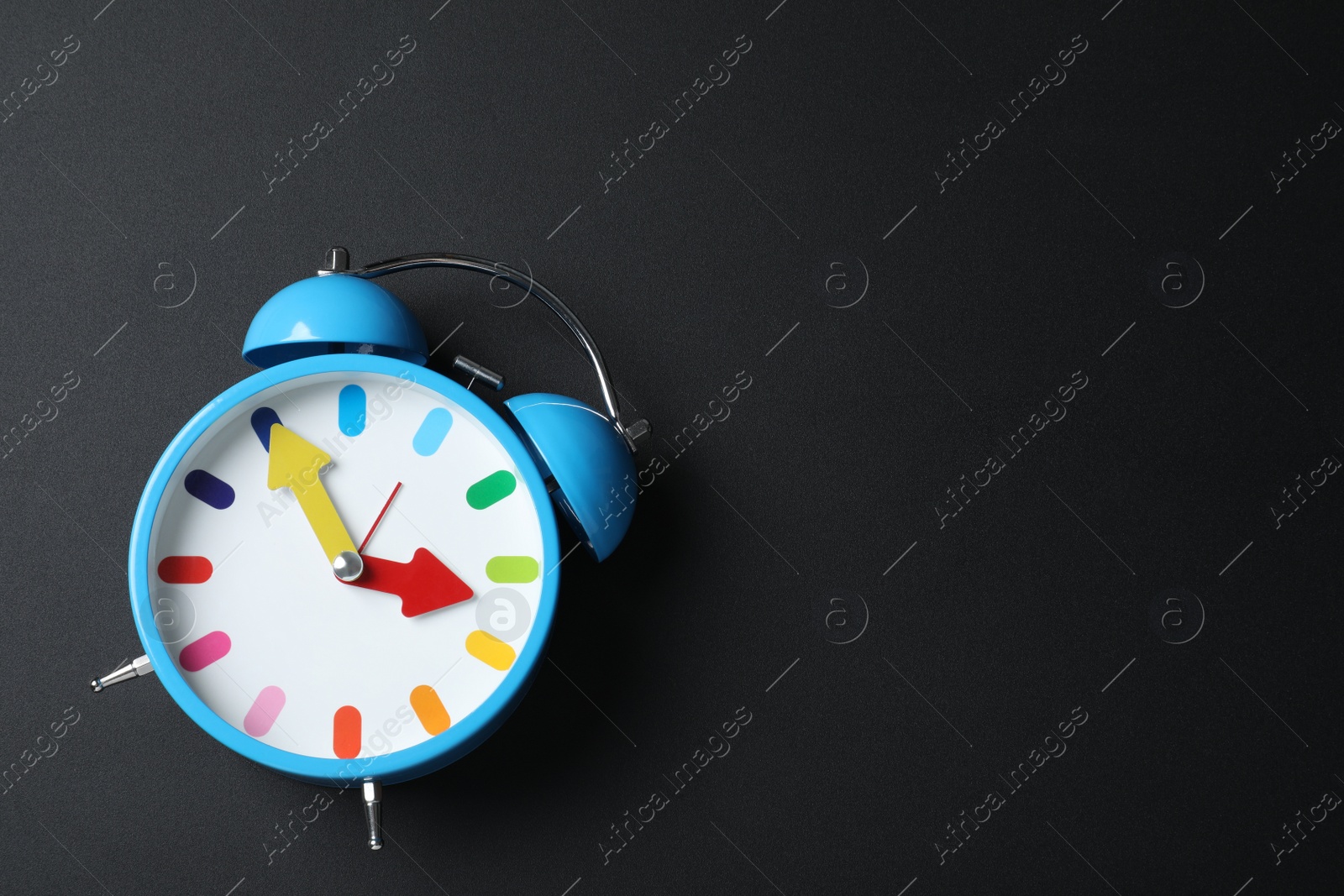 Photo of Alarm clock and space for text on black background, top view. School time