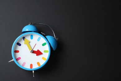 Photo of Alarm clock and space for text on black background, top view. School time