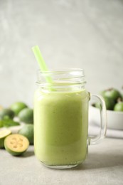 Fresh feijoa smoothie in mason jar on light table, closeup