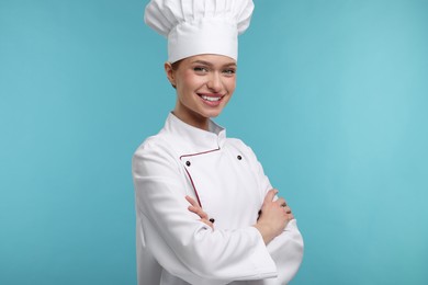 Happy chef in uniform on light blue background