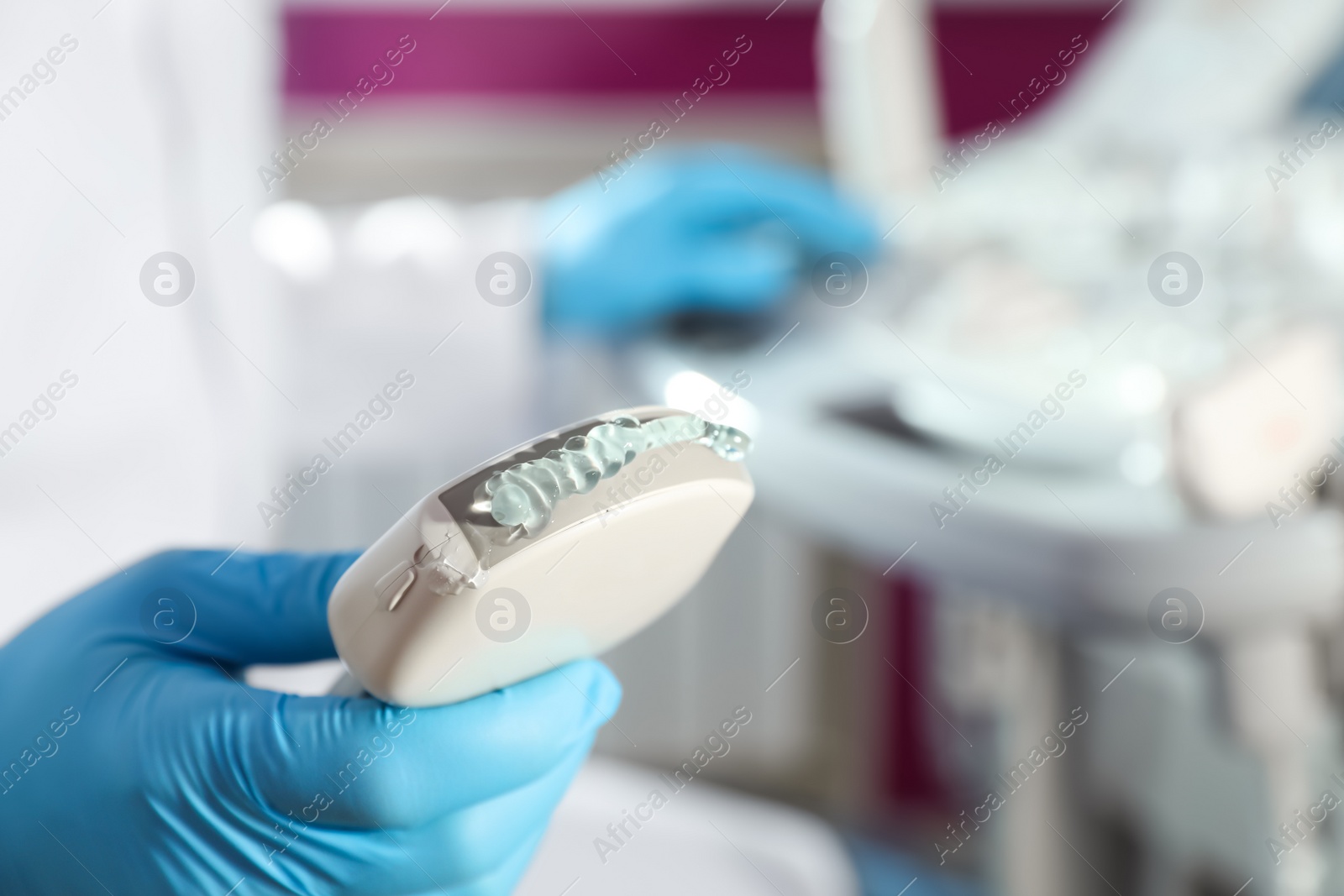 Photo of Sonographer holding ultrasound machine probe with gel in clinic, closeup. Space for text