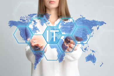 Image of Information technology concept. Woman pointing at world map on light grey background, closeup