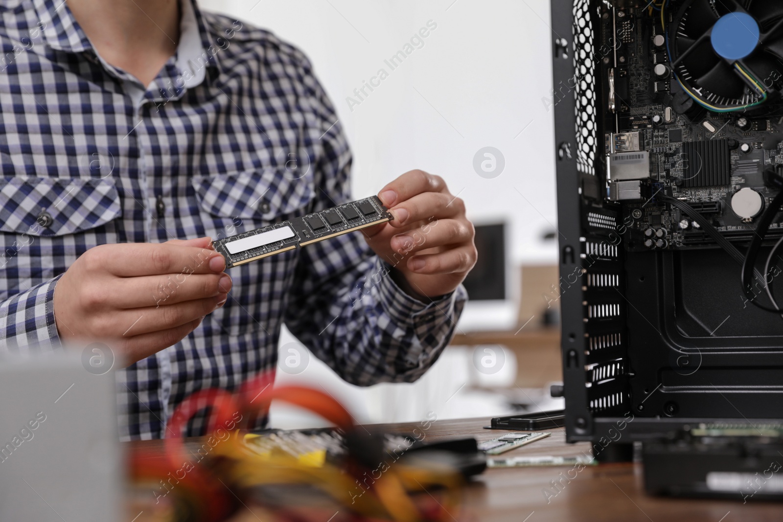 Photo of Male technician repairing computer at table, closeup