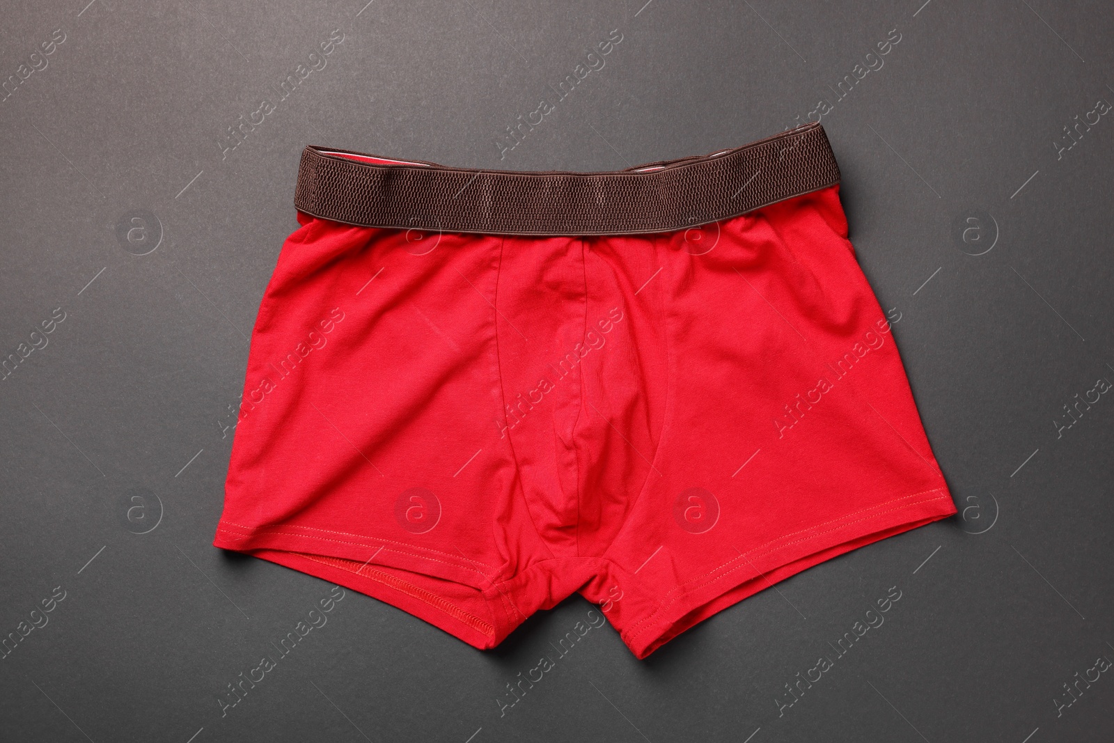 Photo of Red man's underwear on dark grey background, top view