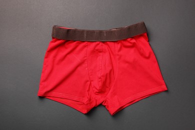 Photo of Red man's underwear on dark grey background, top view