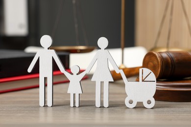 Photo of Family law. Figure of parents with children, books and gavel on wooden table