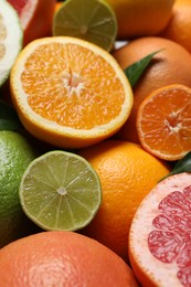 Different fresh whole and cut citrus fruits as background