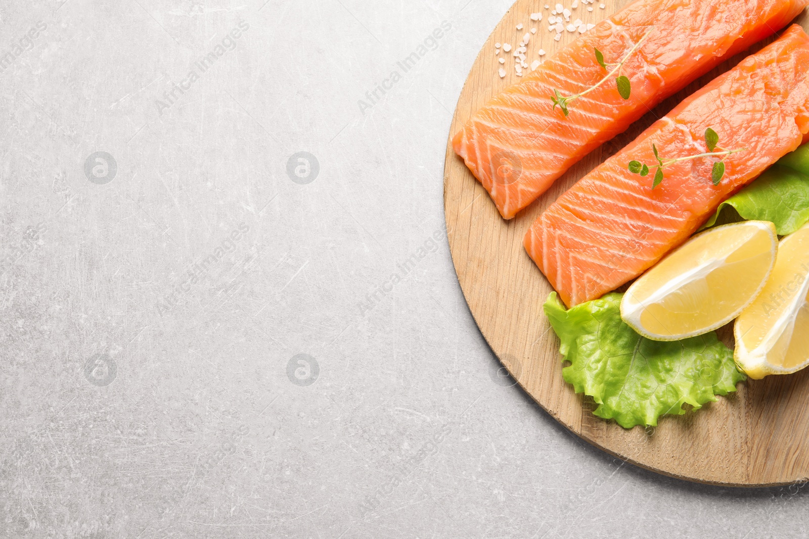 Photo of Fresh raw salmon and ingredients for marinade on light grey table, top view. Space for text