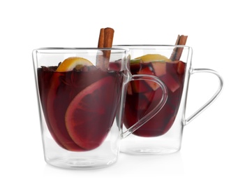 Photo of Cups with red mulled wine against white background