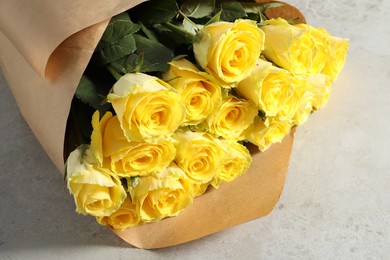 Photo of Beautiful bouquet of yellow roses on light grey table, closeup