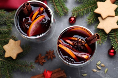 Photo of Flat lay composition with aromatic mulled wine on grey table, closeup