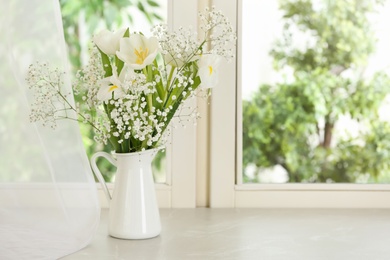 Photo of Beautiful fresh flowers on window sill indoors. Space for text