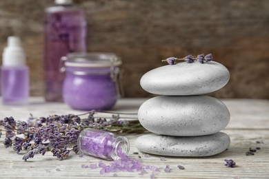 Photo of Composition with lavender flowers, spa stones and natural cosmetic on table