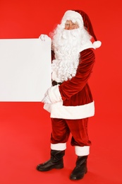 Photo of Authentic Santa Claus with blank banner on red background. Space for design