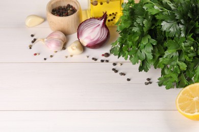 Photo of Fresh green parsley, spices and other products on white wooden table, space for text