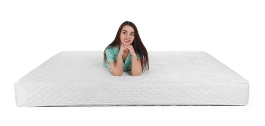 Photo of Young woman lying on mattress against white background