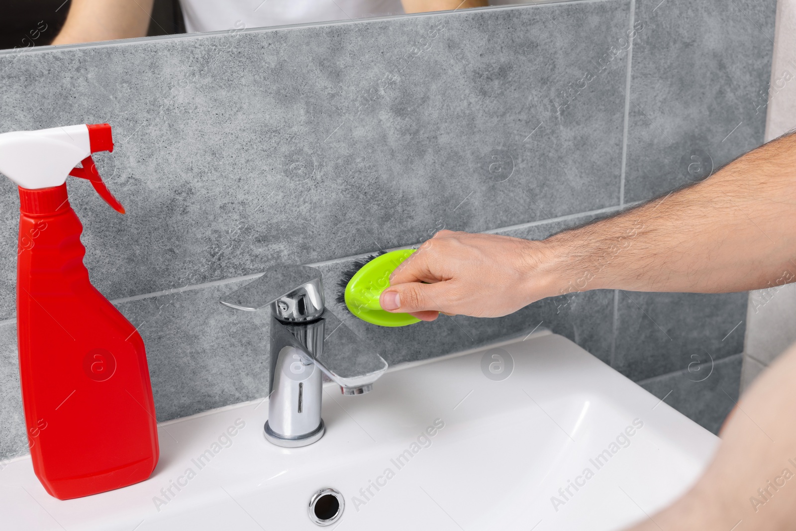 Photo of Man cleaning wall with brush in bathroom, closeup