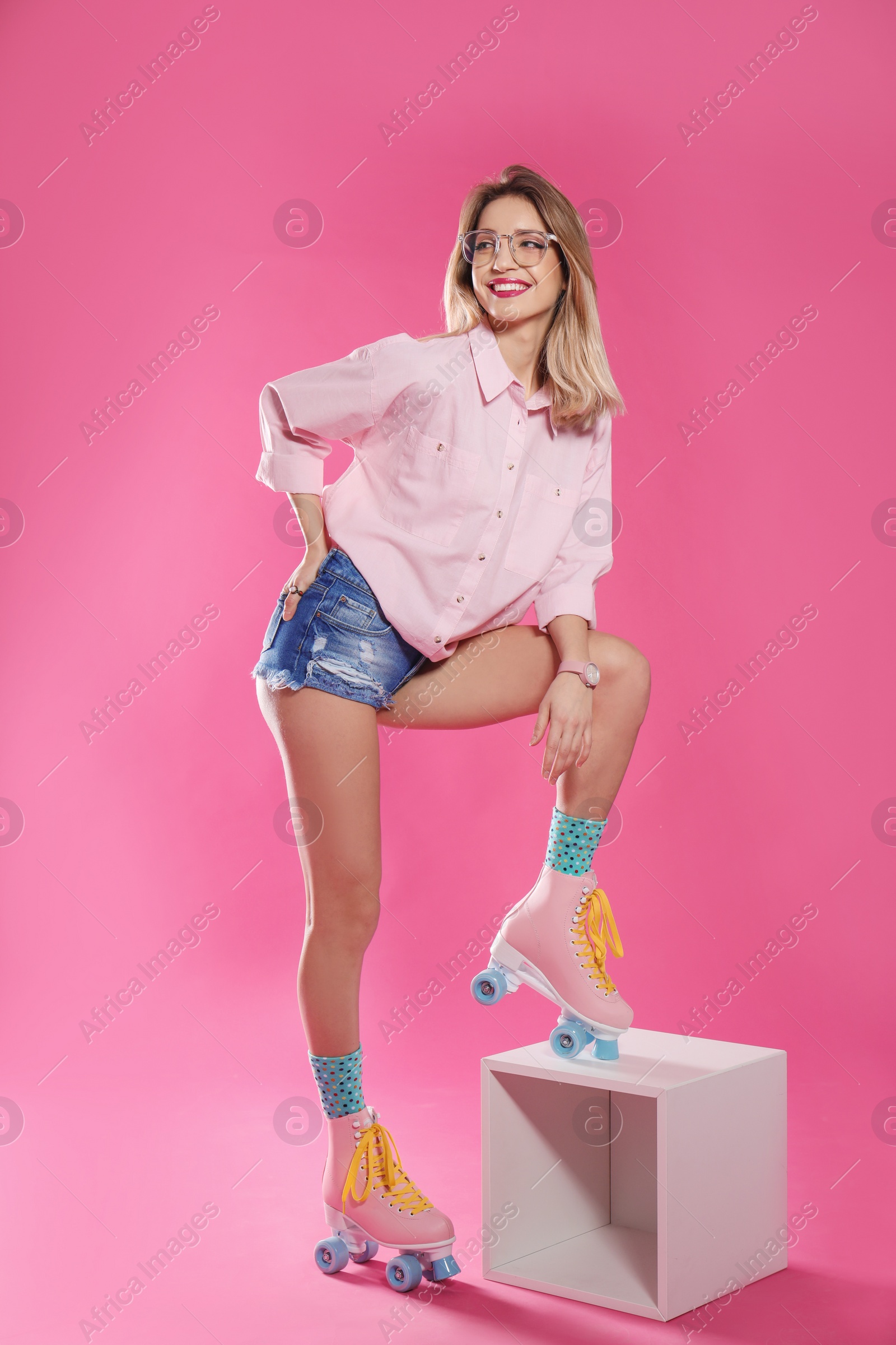 Photo of Young woman with retro roller skates on color background