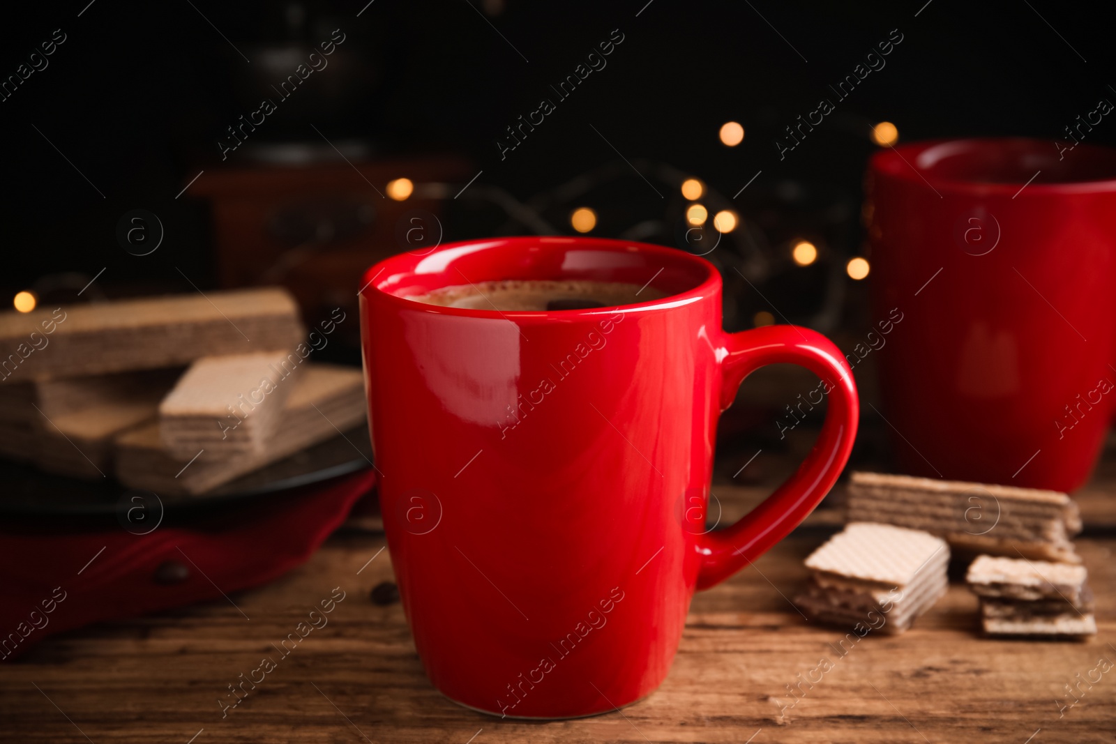 Photo of Delicious coffee and wafers on wooden table