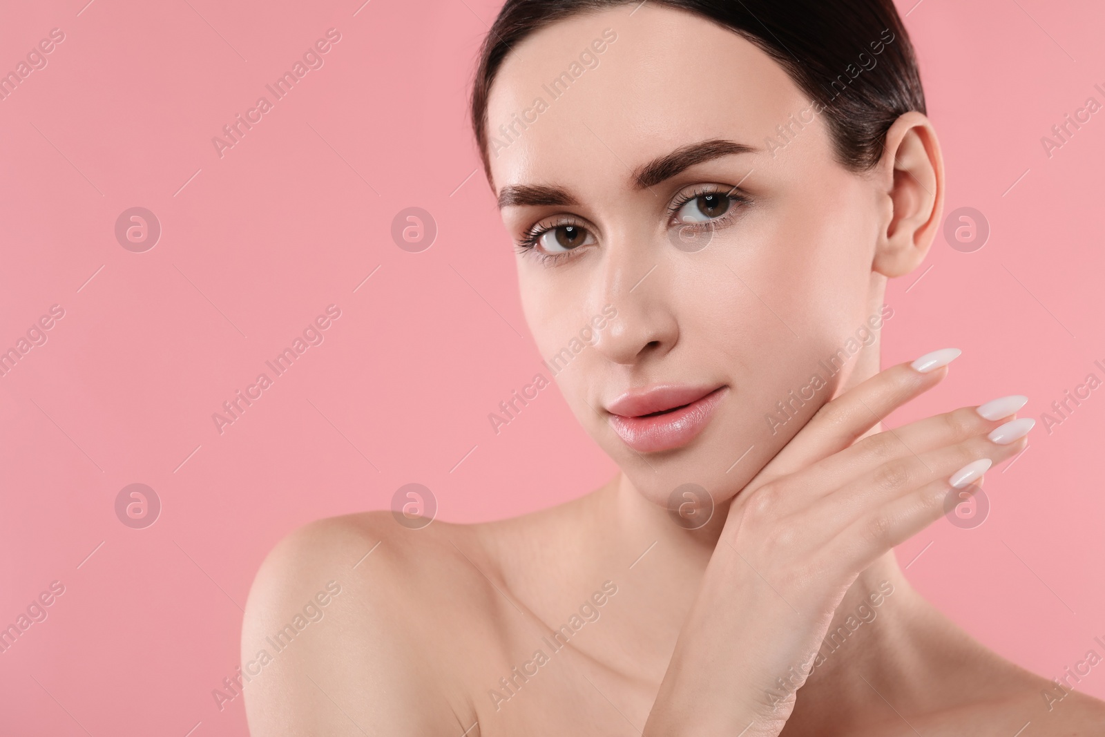 Photo of Portrait of beautiful young woman on pink background. Space for text