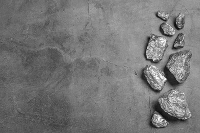 Photo of Many silver nuggets on grey table, flat lay. Space for text