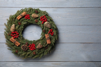 Beautiful Christmas wreath on grey wooden background, top view. Space for text