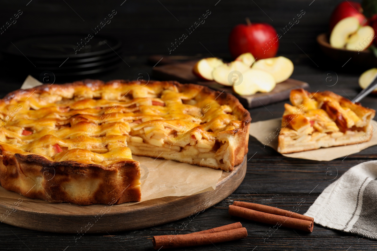 Photo of Traditional apple pie on black wooden table