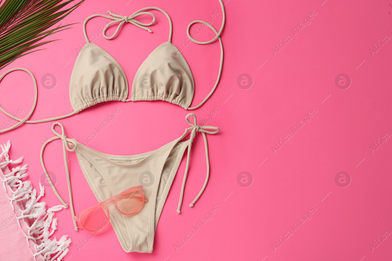 Photo of Flat lay composition with stylish bikini on pink background. Space for text