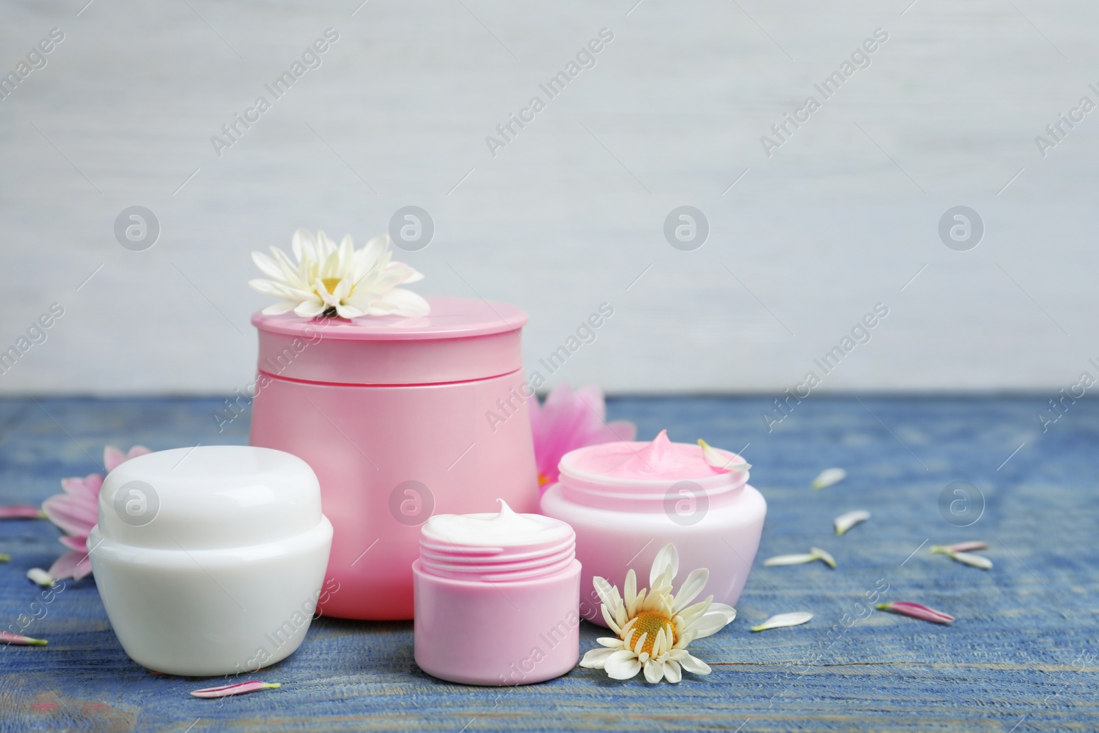 Photo of Composition with body cream in jars on light background