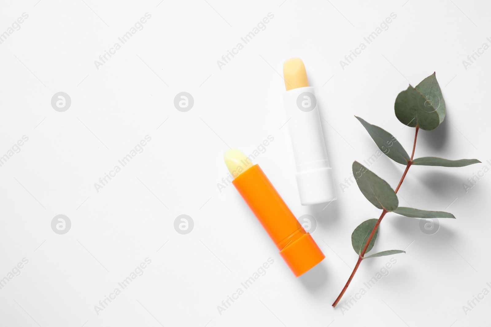 Photo of Hygienic lipsticks on white background, top view