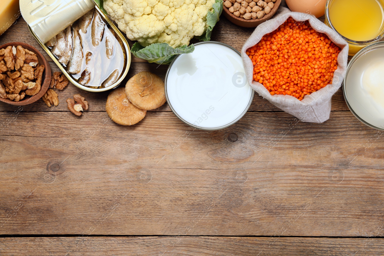 Photo of Set of natural food high in calcium on wooden table, flat lay. Space for text