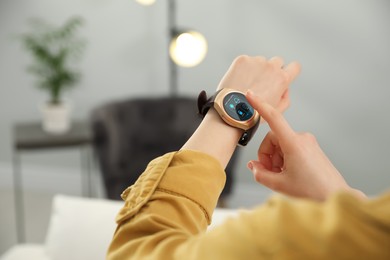 Image of Woman setting smart home control system via smartwatch indoors, closeup. App interface with icons on display