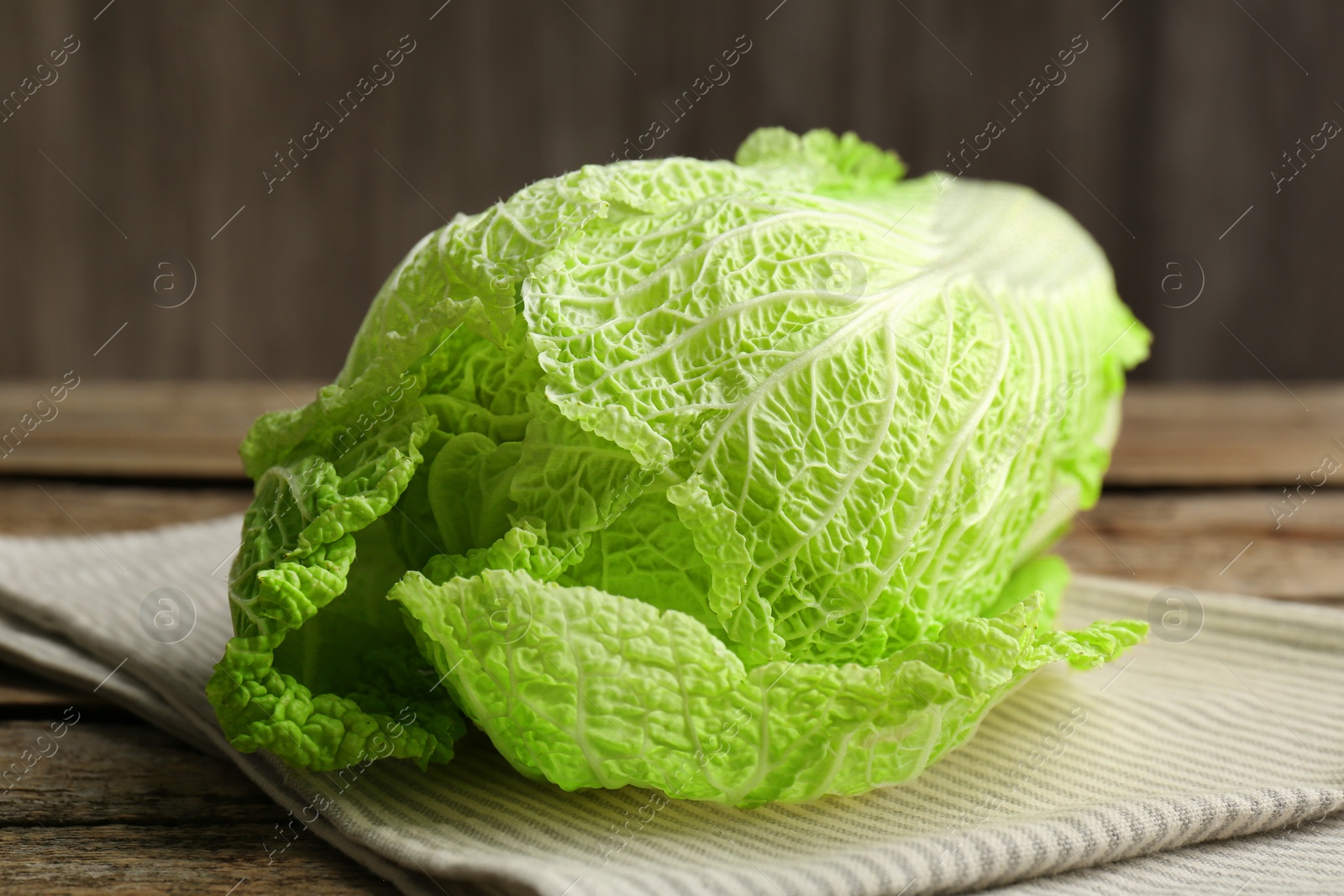 Photo of Fresh ripe Chinese cabbage on wooden table, closeup