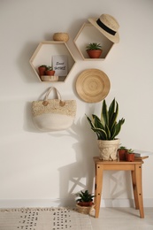 Photo of Room interior with hexagon wooden shelves on light wall