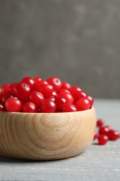 Photo of Tasty ripe cranberries on grey wooden table, closeup