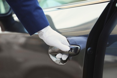 Photo of Closeup view of chauffeur opening car door