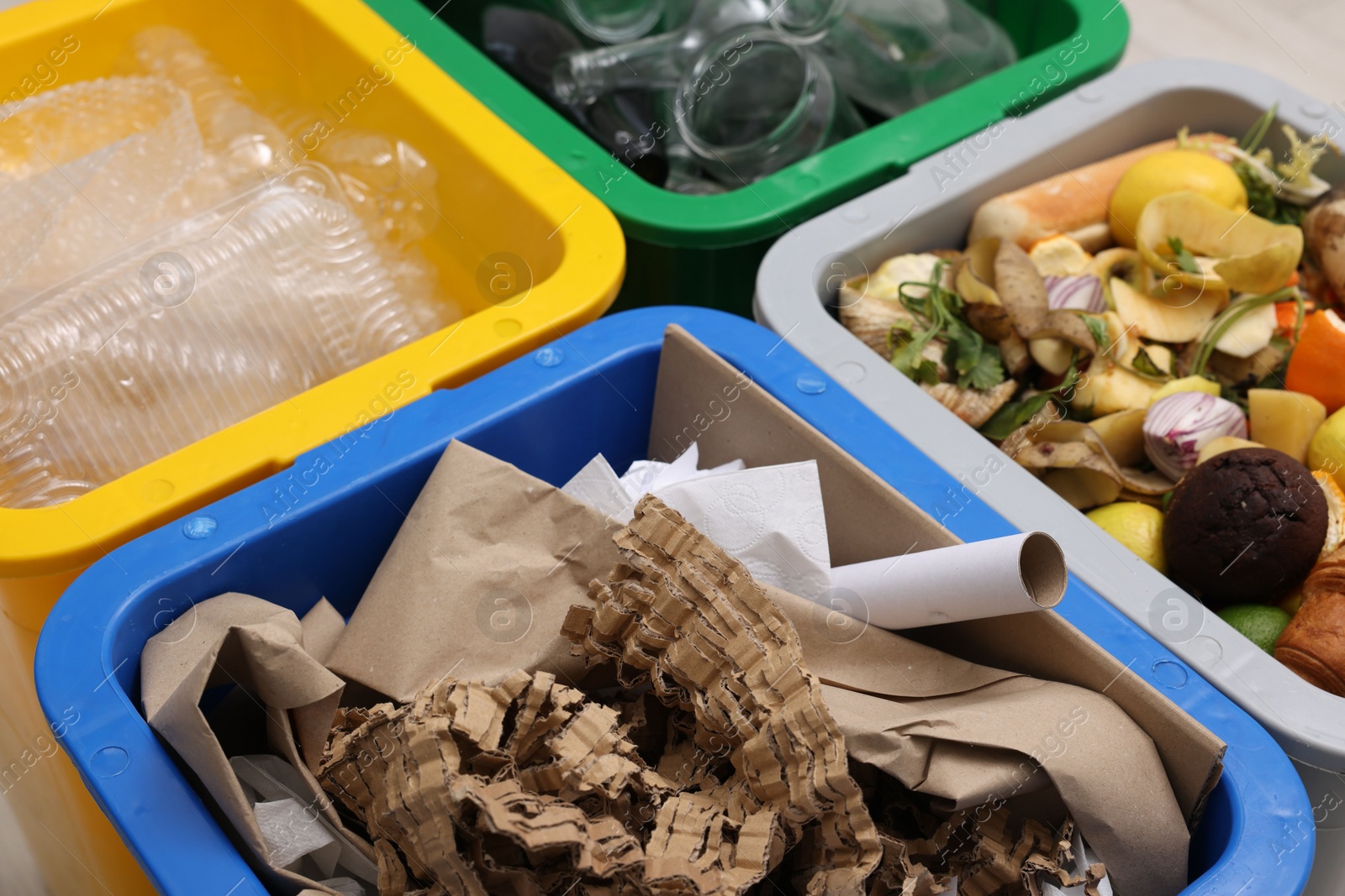 Photo of Garbage sorting. Full trash bins for separate waste collection indoors, closeup