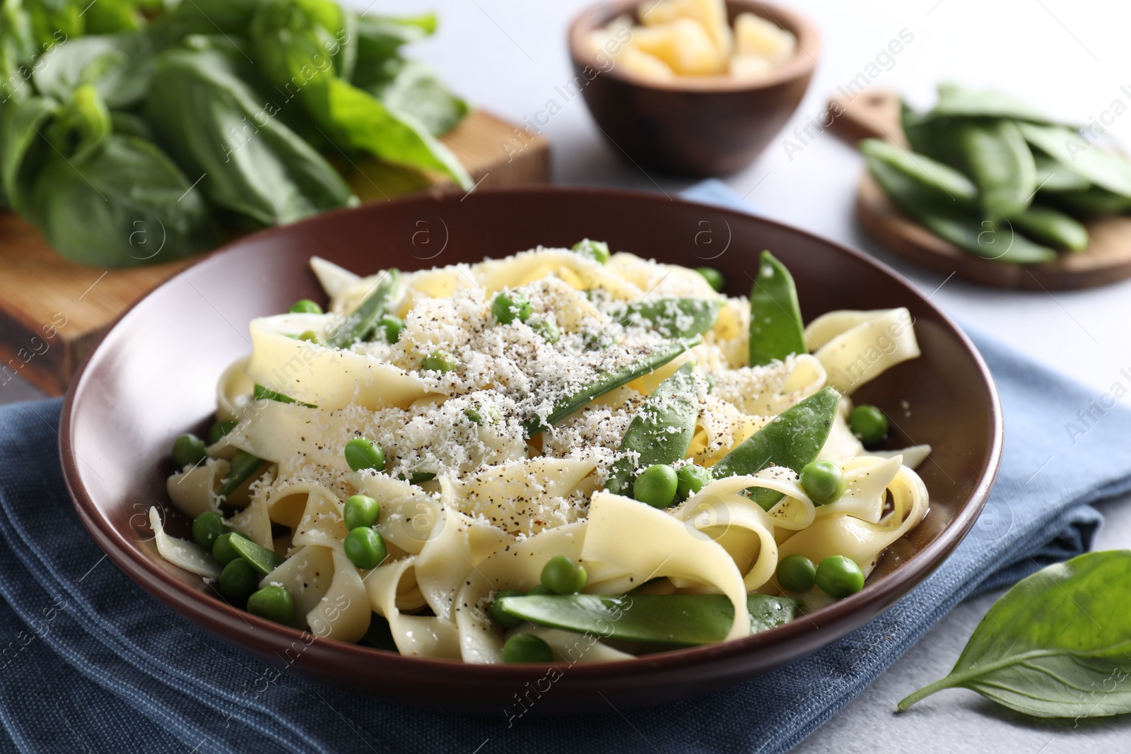 Photo of Delicious pasta with green peas on grey table, closeup