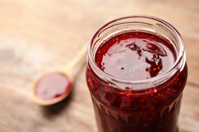 Photo of Homemade delicious raspberry jam on table, closeup