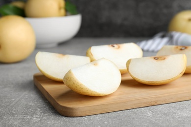 Photo of Slices of ripe apple pear on grey table
