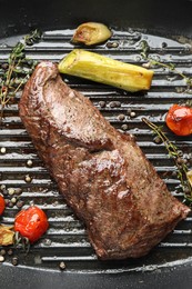 Photo of Delicious grilled beef meat and vegetables in pan, top view
